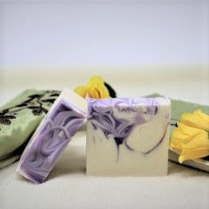 Two bars of By the Sea Soap Shoppe "Luscious Lavender" bars of soap showing the white bars with the purple swirls of colour throughout and the purple swirls on the top of the bar. $7.00 each. 