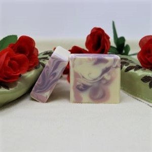 By the Sea Soap Shoppe bar of soap called "Rose and Lavender". Picture shows two bars of soap that are white with mauve and purple swirls. Soap includes Rose Essential Oil and Lavender Essential Oil. Vegan, all-natural ingredients, handmade in Prince Edward Island. $7.00 each