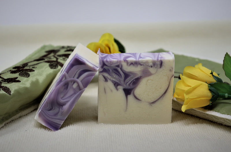 Two bars of By the Sea Soap Shoppe "Luscious Lavender" bars of soap showing the white bars with the purple swirls of colour throughout and the purple swirls on the top of the bar. $7.00 each. 
