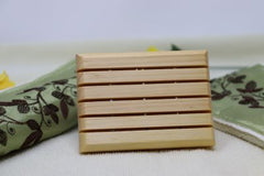 Light brown wooden soap saver made of white pine. It has five slats as well as holes for drainage.  Made of white pine, it is durable and stands up to water. $5.00 each.